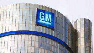 청명한 하늘을 배경으로 회사 건물에 있는 General Motors(GM) 로고 이미지.