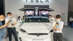 코로나19 팬데믹 기간 동안 중국 자동차 박람회에 전시된 Tesla(TSLA) 모델 X. 마스크를 착용한 직원.